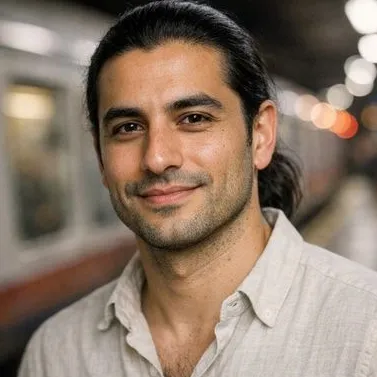 Early-thirties man, olive skin, black hair in low ponytail, calm expression